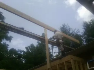 Carpenter setting a ridge beam over a new addition frame — Ice Dam Removal by Roofing Brothers in Ninnekah