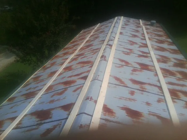 Rusted metal roof panels with new wood purlins before replacement — Storm Damage Roof Repair in Ninnekah by Roofing Brothers