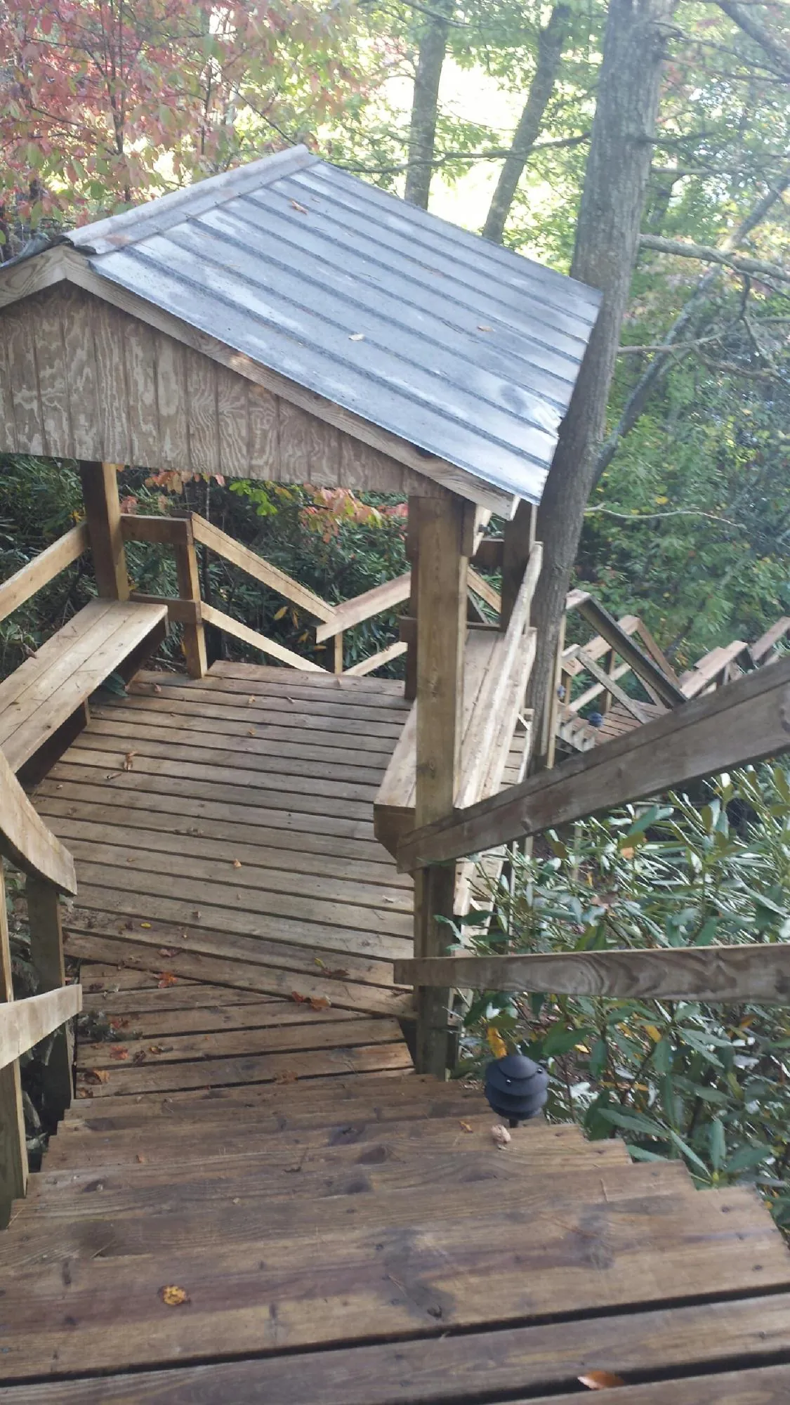 Metal roofed shelter over wooden steps on a wooded walkway — Skylight Repair & Installation work by our crew in Ninnekah