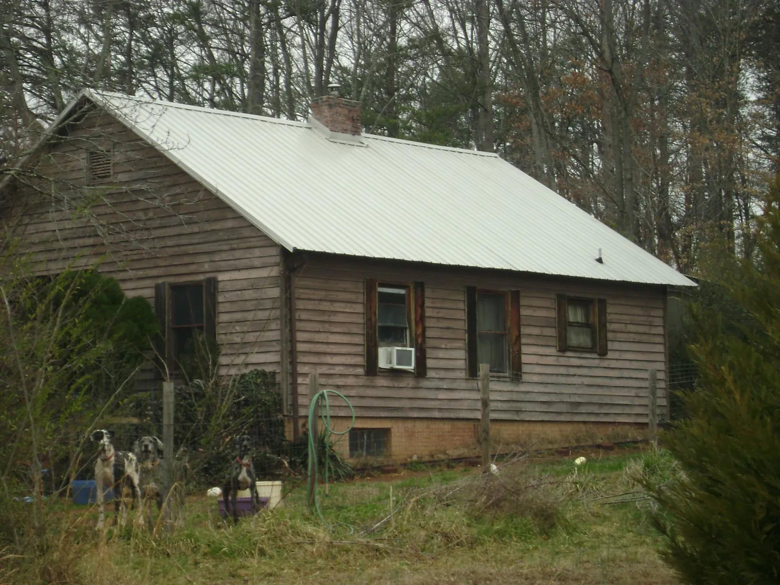 White metal roof on an old wood sided farmhouse, from a Metal Roof Installation job in Ninnekah